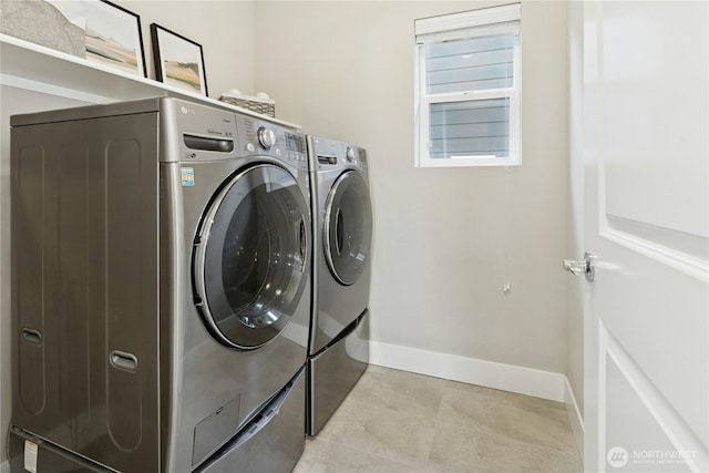 washroom with laundry area, baseboards, light tile patterned floors, and washer and dryer
