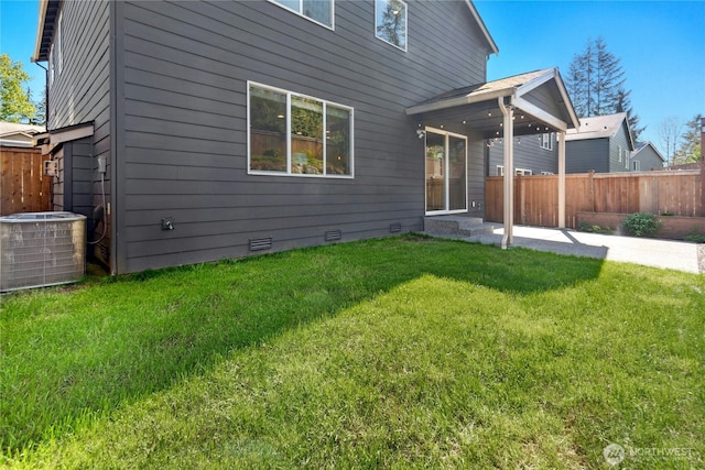 back of house with central AC unit, fence, a yard, and crawl space