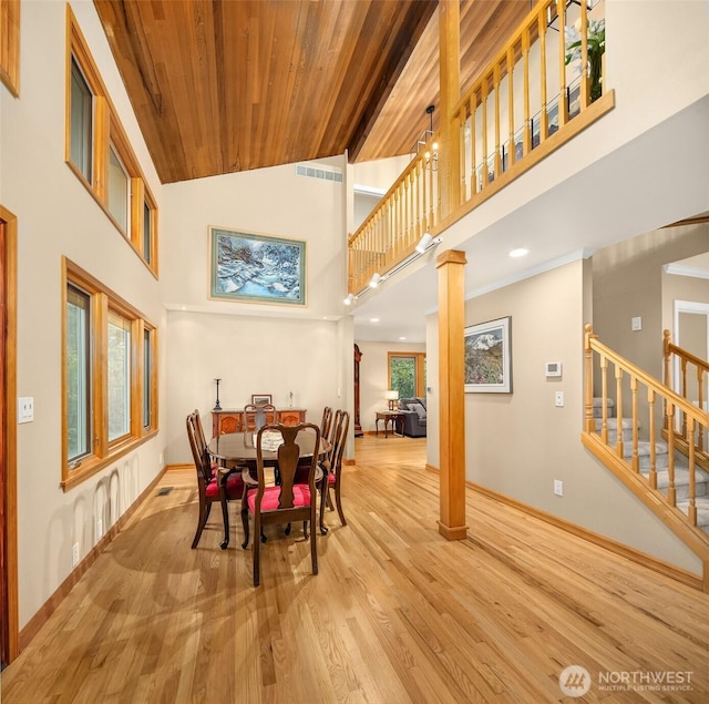 dining room with decorative columns, visible vents, wood finished floors, stairway, and baseboards