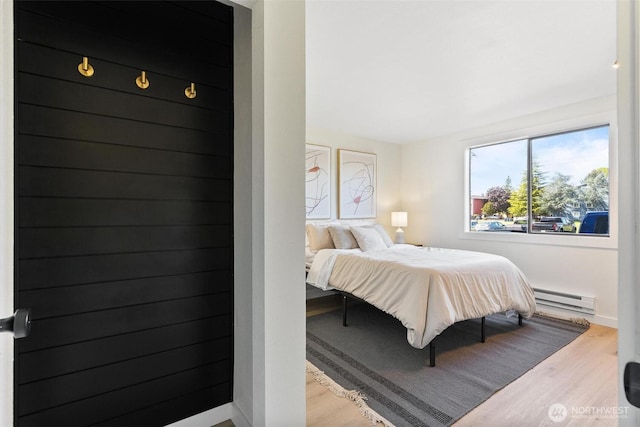 bedroom featuring baseboards, baseboard heating, and wood finished floors