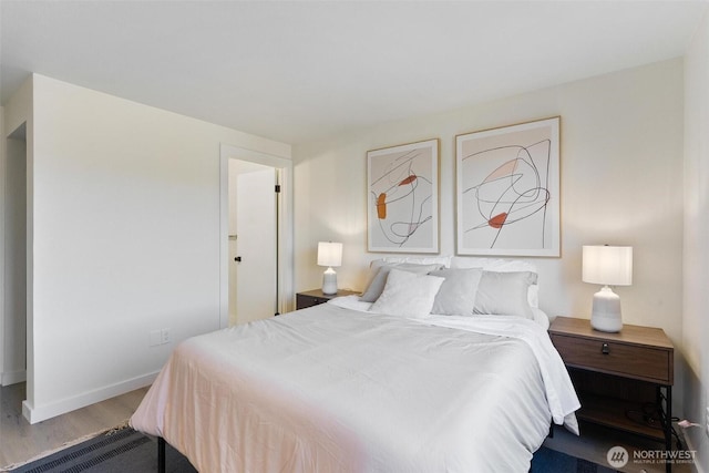 bedroom with baseboards and wood finished floors