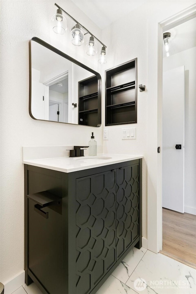bathroom featuring vanity, marble finish floor, and baseboards