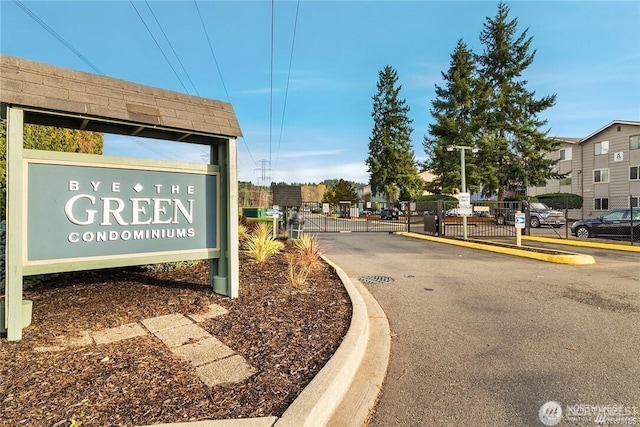 community / neighborhood sign featuring fence