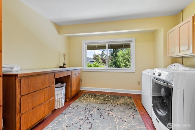washroom with cabinet space, washing machine and clothes dryer, dark wood-type flooring, and baseboards