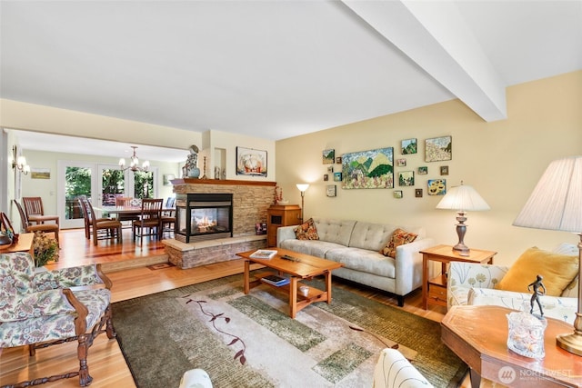 living area featuring wood finished floors, a chandelier, and a fireplace
