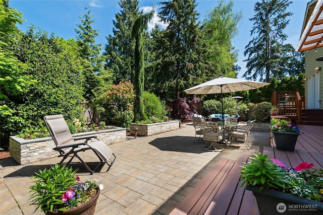 view of patio with outdoor dining area and a wooden deck