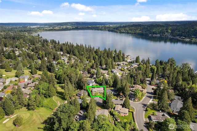 aerial view of residential area featuring property parcel outlined, a large body of water, and a heavily wooded area