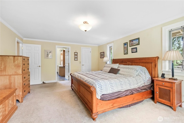 bedroom with light colored carpet, ornamental molding, baseboards, and connected bathroom