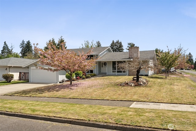 single story home with a chimney, an attached garage, concrete driveway, and a front yard