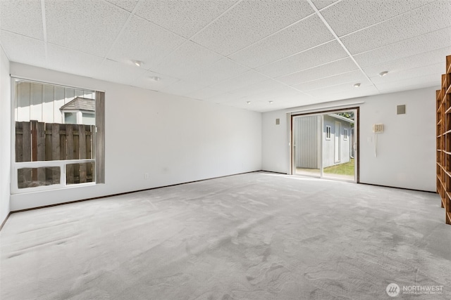 unfurnished room featuring carpet floors, a wealth of natural light, baseboards, and a paneled ceiling