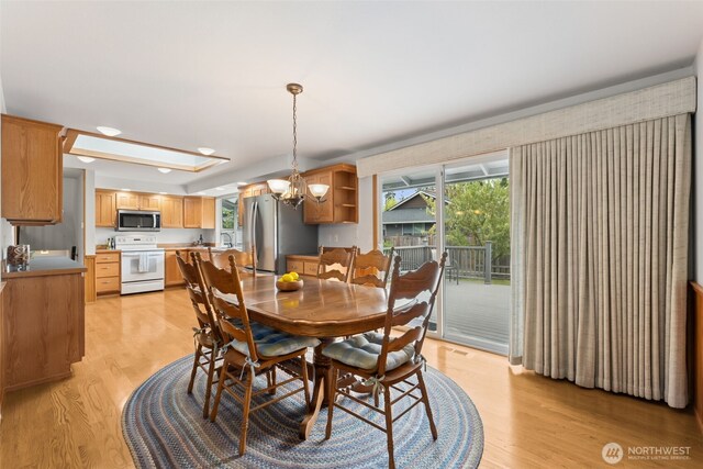 dining space with light wood finished floors and a chandelier
