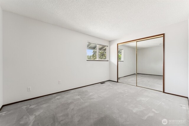 unfurnished bedroom with a closet, carpet flooring, baseboards, and visible vents