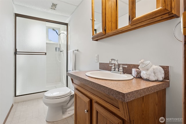 bathroom featuring vanity, a stall shower, and toilet