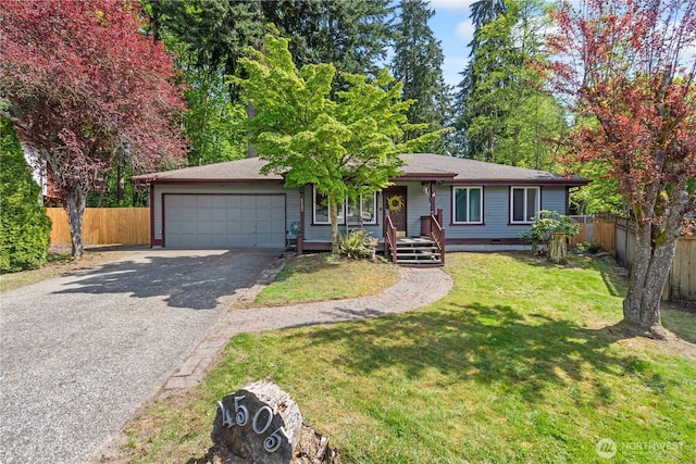 ranch-style house featuring a front lawn, fence, covered porch, an attached garage, and driveway