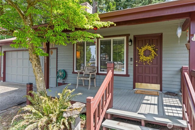 entrance to property featuring a garage and a porch