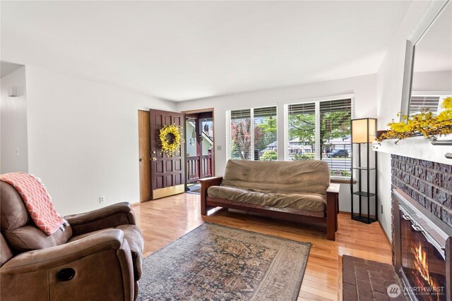 living room with a fireplace and light wood-type flooring