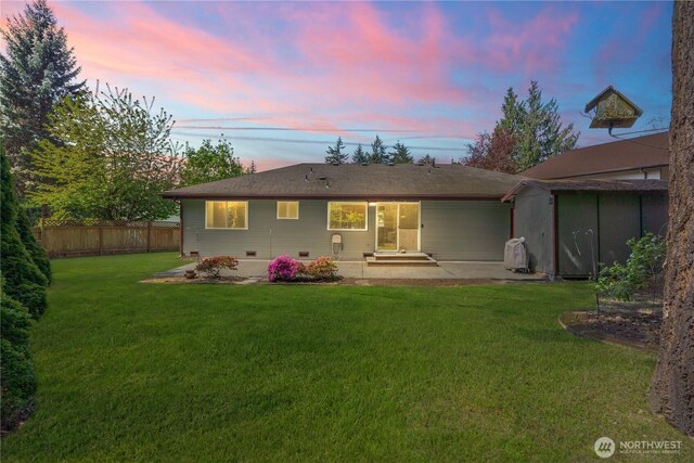 back of house featuring a lawn, an outbuilding, a patio area, fence, and a shed