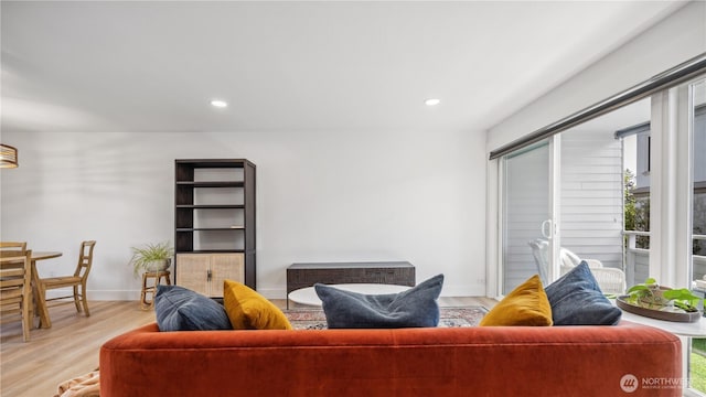 living room featuring recessed lighting, baseboards, and light wood-type flooring