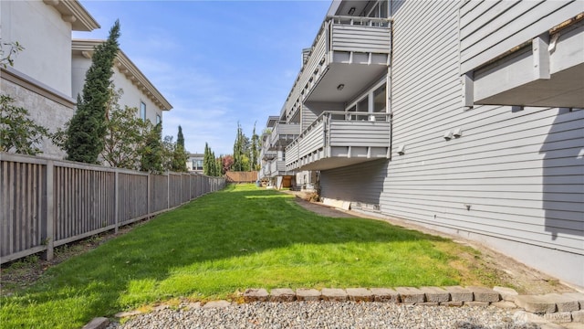 view of yard with fence and a balcony