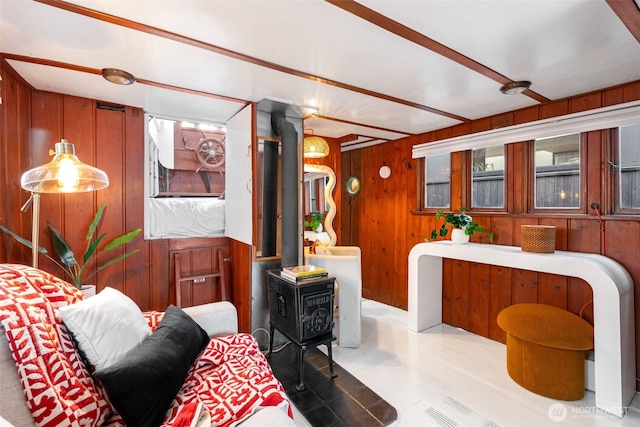 living area featuring a wood stove and wooden walls