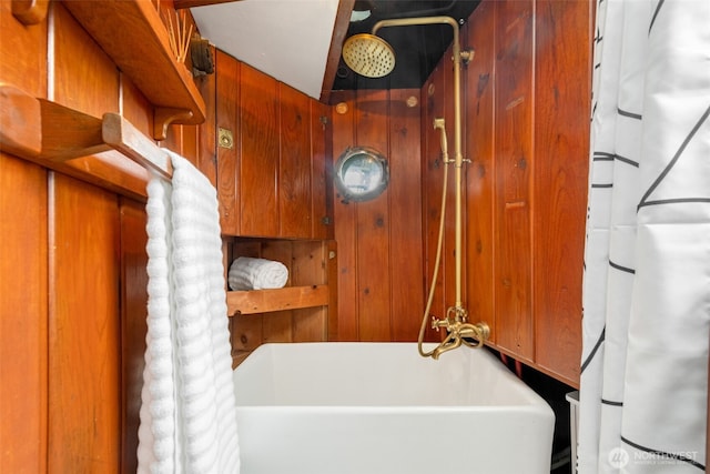 bathroom with a washtub and a shower with shower curtain
