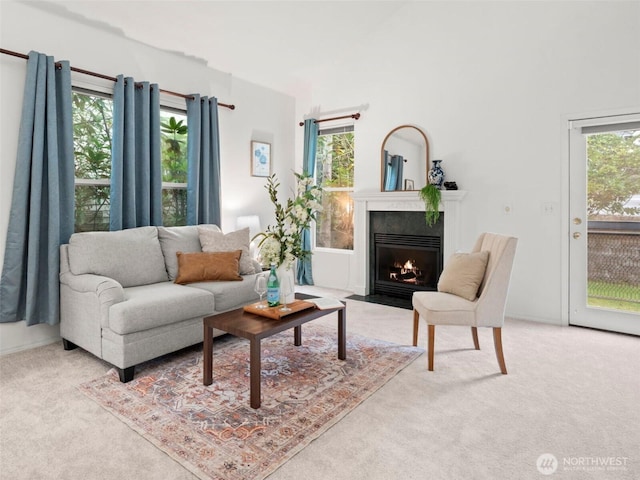 living room with a fireplace with flush hearth and carpet