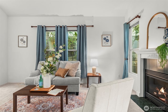 living area featuring a healthy amount of sunlight, carpet flooring, and a tile fireplace