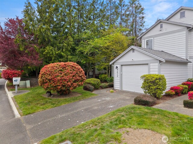 view of home's exterior featuring aphalt driveway, roof with shingles, and a garage