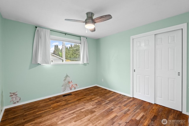 2617 College St SE, Lacey, WA 98503 - unfurnished bedroom with visible vents, a closet, wood finished floors, baseboards, and a ceiling fan
