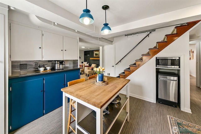 12739 7th Ave NW, Seattle, WA 98177 - kitchen with carpet flooring, blue cabinets, dark countertops, stainless steel appliances, and white cabinets