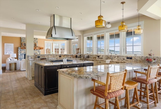 5848 Mutiny Bay Rd, Freeland, WA 98249 - kitchen with a kitchen breakfast bar, island range hood, stainless steel gas cooktop, light stone countertops, and a peninsula