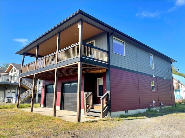 415 Olympic View Dr NE, Ocean Shores, WA 98569 - rear view of property with an attached garage and a wooden deck