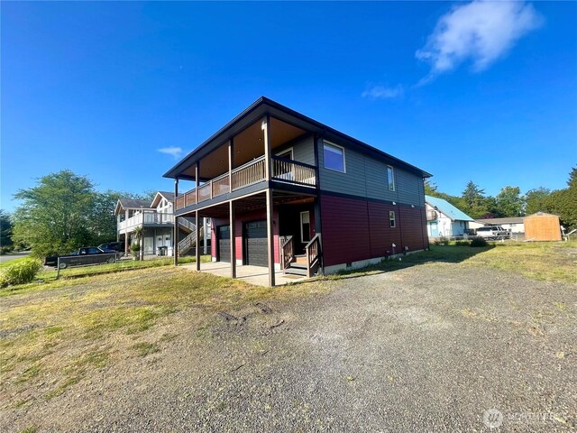 415 Olympic View Dr NE, Ocean Shores, WA 98569 - back of property featuring a wooden deck, stairway, and crawl space