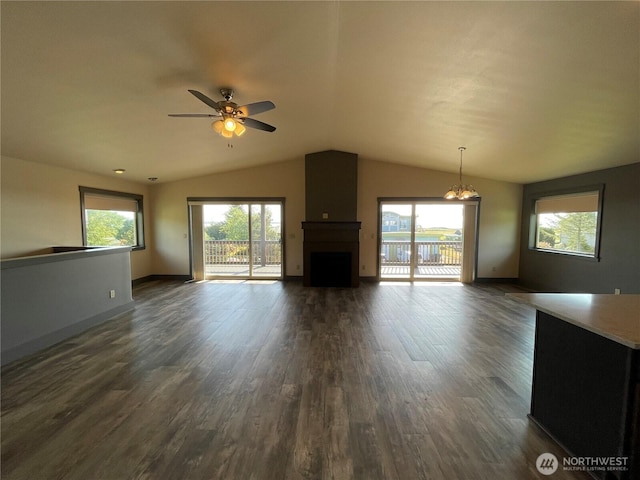 415 Olympic View Dr NE, Ocean Shores, WA 98569 - unfurnished living room with lofted ceiling, ceiling fan, a large fireplace, dark wood-style floors, and plenty of natural light