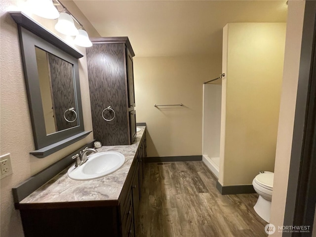 415 Olympic View Dr NE, Ocean Shores, WA 98569 - full bathroom with wood finished floors, toilet, vanity, a shower, and baseboards