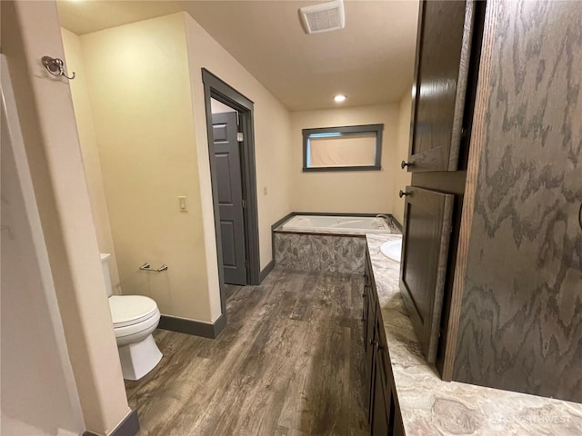415 Olympic View Dr NE, Ocean Shores, WA 98569 - full bathroom featuring wood finished floors, toilet, a bath, and baseboards