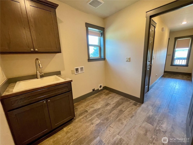 415 Olympic View Dr NE, Ocean Shores, WA 98569 - washroom with hookup for a washing machine, wood finished floors, baseboards, and cabinet space
