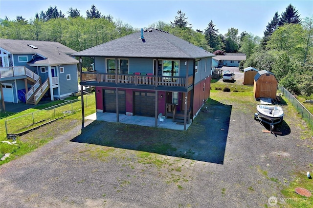 415 Olympic View Dr NE, Ocean Shores, WA 98569 - back of house with driveway, roof with shingles, and an attached garage