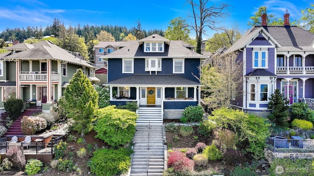view of front of property featuring a residential view, stairs, and roof with shingles