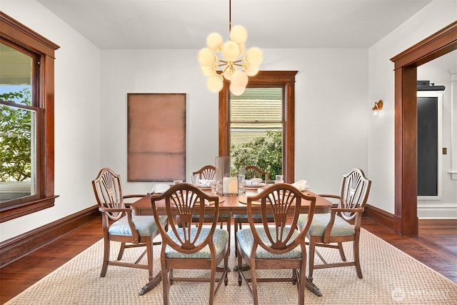dining area with an inviting chandelier, baseboards, and wood finished floors