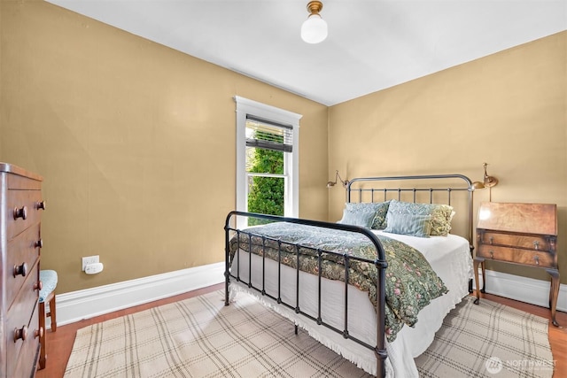bedroom featuring baseboards and wood finished floors