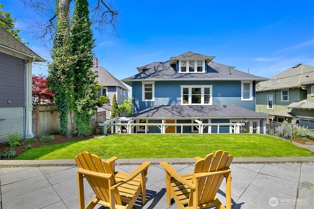 rear view of house with a yard, a patio, and a fenced backyard