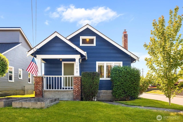 1002 S Adams St, Tacoma, WA 98405 - view of front of property featuring a front yard, a chimney, a garden, and a porch
