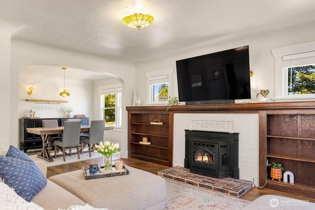 1002 S Adams St, Tacoma, WA 98405 - living room featuring wood finished floors, plenty of natural light, arched walkways, and a fireplace