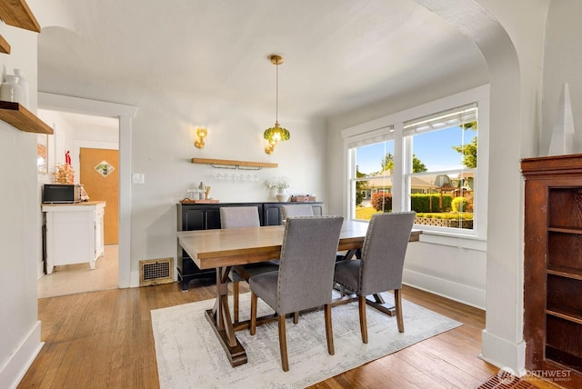 1002 S Adams St, Tacoma, WA 98405 - dining space with hardwood / wood-style floors, baseboards, and arched walkways