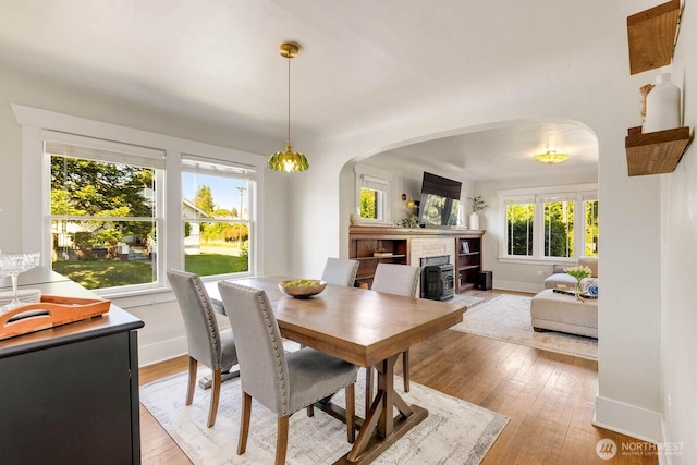 1002 S Adams St, Tacoma, WA 98405 - dining space with arched walkways, light wood-style floors, and baseboards