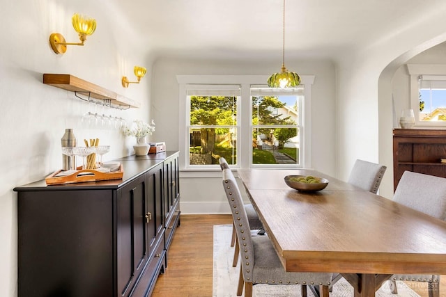 1002 S Adams St, Tacoma, WA 98405 - dining space with light wood-style flooring, arched walkways, and baseboards