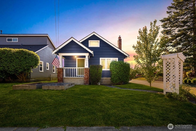 1002 S Adams St, Tacoma, WA 98405 - view of front of home featuring a chimney, a yard, covered porch, and brick siding