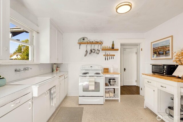 1002 S Adams St, Tacoma, WA 98405 - kitchen with white electric range oven, black microwave, and white cabinetry