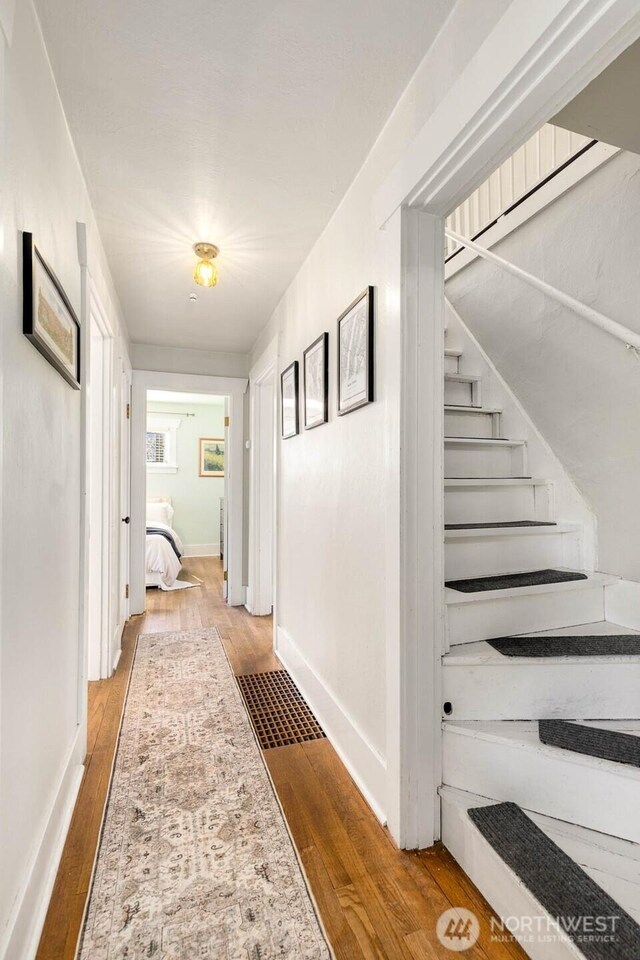 1002 S Adams St, Tacoma, WA 98405 - hallway with wood finished floors, stairway, and baseboards